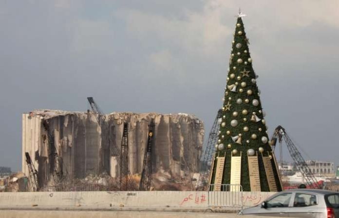 A Christmas tree with names of those who died during Beirut port explosion, is seen near the damaged grain silo, in Beirut, Lebanon December 22, 2020. REUTERS-Mohamed Azakir