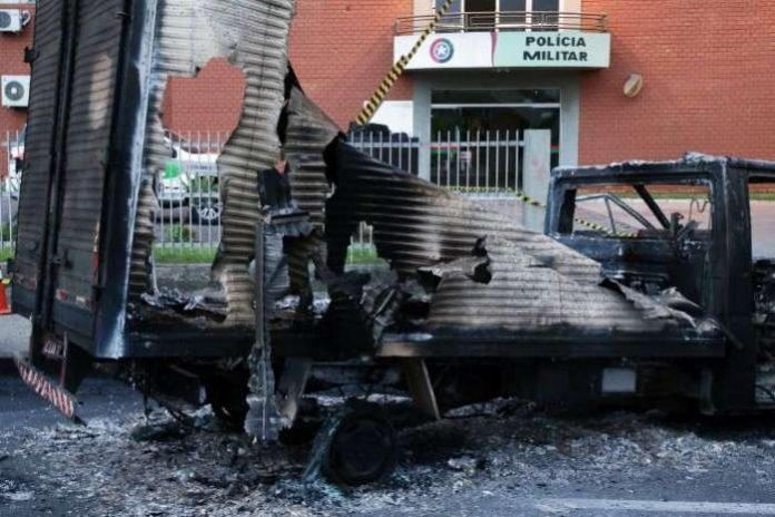 A burned-out truck blocks the military police battalion station, placed there by a gang that robbed a Banco do Brasil (Bank of Brazil) branch in Criciuma, Santa Catarina state, Brazil [Guilherme Ferreira-Reuters]