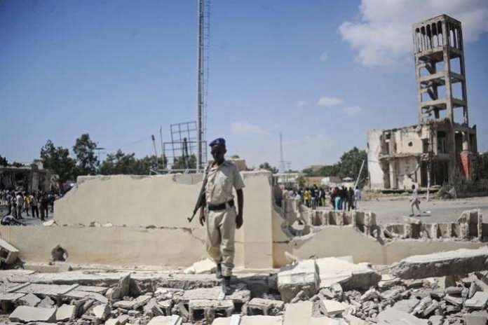A Somali security officer stands at the scene of a car bombing attack in Mogadishu, Somalia. AFP