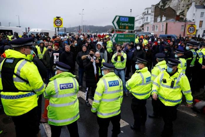 Drivers stand in front of police officers as they block the exit at the Port of Dover, as EU countries impose a travel ban from the UK following the coronavirus disease (COVID-19) outbreak, in Dover, Britain, December 23, 2020. REUTERS-John Sibley