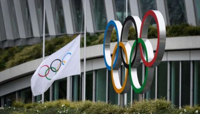 The Olympic Rings are pictured in front of the headquarters of the International Olympic Committee (IOC) in Lausanne on March 22, 2020, as doubts increase over whether Tokyo can safely host the summer Games amid the spread of the COVID-19. – The global sporting calendar has been swept away by the coronavirus pandemic but the International Olympic Committee has insisted the Tokyo Games will go ahead in four months despite growing calls for a postponement. (Photo by FABRICE COFFRINI / AFP) The Olympic Rings are pictured in front of the headquarters of the International Olympic Committee (IOC) in Lausanne on March 22, 2020, as doubts increase over whether Tokyo can safely host the summer Games amid the spread of the COVID-19. – The global sporting calendar has been swept away by the coronavirus pandemic but the International Olympic Committee has insisted the Tokyo Games will go ahead in four months despite growing calls for a postponement. (Photo by FABRICE COFFRINI / AFP)