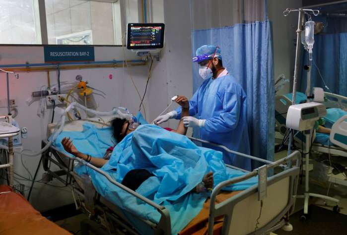 A medical worker tends to a patient suffering from coronavirus disease (COVID-19), as a Syringe Infusion Pump, donated by France is seen next to his bed, inside the emergency room of Safdarjung Hospital in New Delhi, India, May 7, 2021. REUTERS