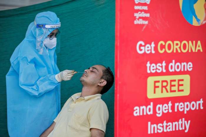 A healthcare worker wearing personal protective equipment (PPE) takes swab from a man during a testing campaign for the coronavirus disease (COVID-19), in Ahmedabad, India November 24, 2020. REUTERS-Amit Dave