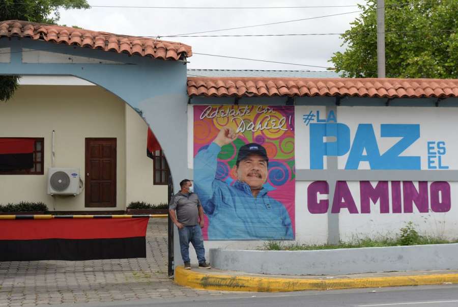 A man stands next to a photo of Nicaraguan President Daniel Ortega on a wall promoting his candidacy for the upcoming November 7 general election, outside the Ministry of Agriculture in Managua, Nicaragua June 30, 2021. REUTERS-Stringer
