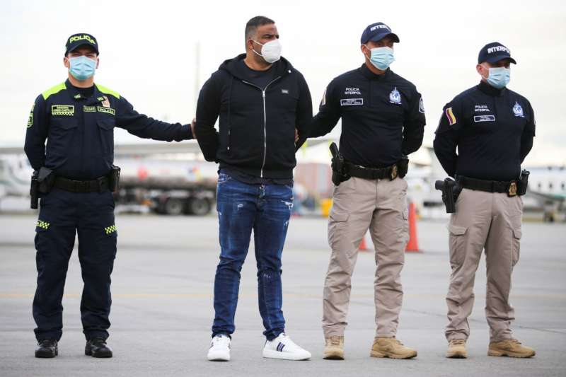 Alexander Montoya Usuga, alias "el flaco", an alleged member of the 'Clan del Golfo' and cousin of the top leader of that organized armed group, Dario Antonio Usuga alias "Otoniel", is escorted by the police, before being extradited to the U.S., to answer for alleged drug trafficking crimes, at an airport in an anti-narcotics base in Bogota, Colombia, August 19, 2021. REUTERS/Luisa Gonzalez